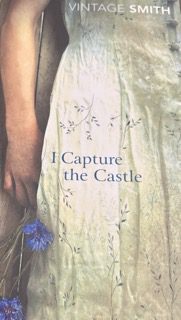 A book cover for "I Capture the Castle" by Dodie Smith, showing a young woman in a pale, patterned dress holding blue flowers at her side. The design features soft, muted colors and evokes a dreamy, nostalgic feeling, suitable for readers with ADHD seeking gentle, visually calming imagery.